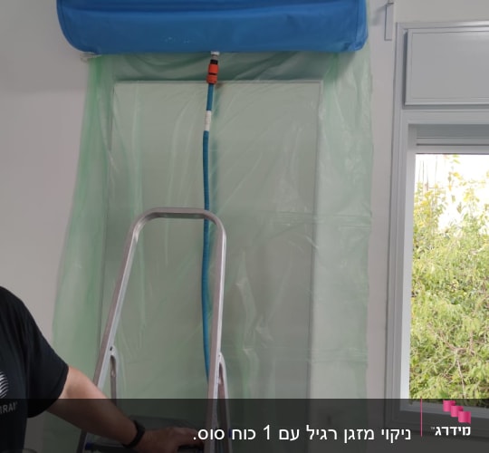 מזגן מפורק עם יריעה כחולה וירוקה